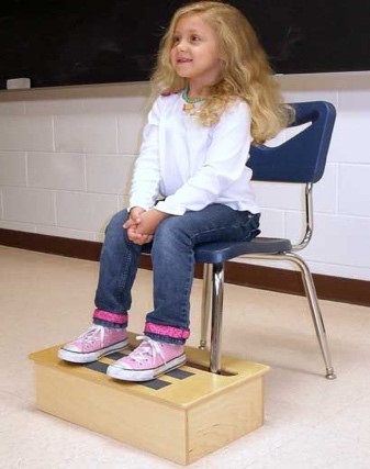 Photo of a girl sitting in a chair with a footrest set at the right height