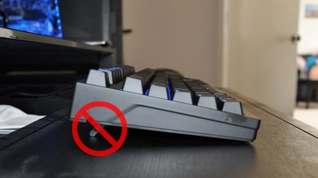 Photo of a keyboard with feet up in the back crossed out