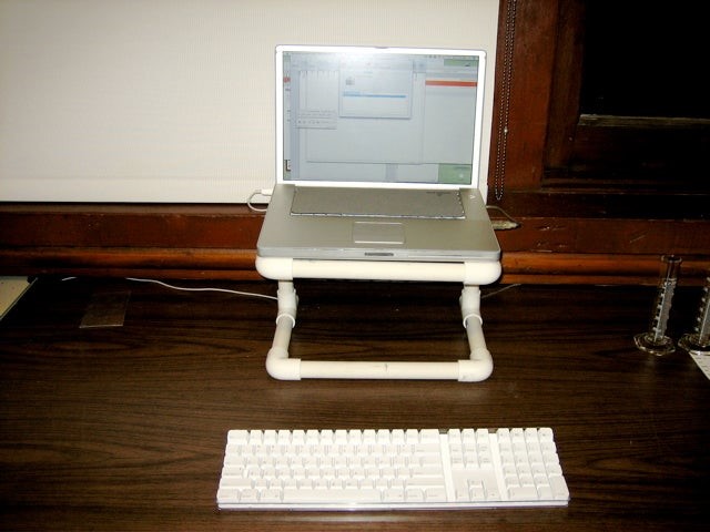 Photo of a laptop resting on a stand made of PVC pipes